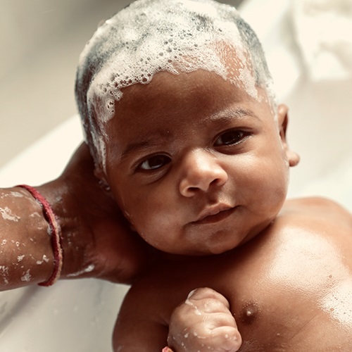 Baby receiving a bath.