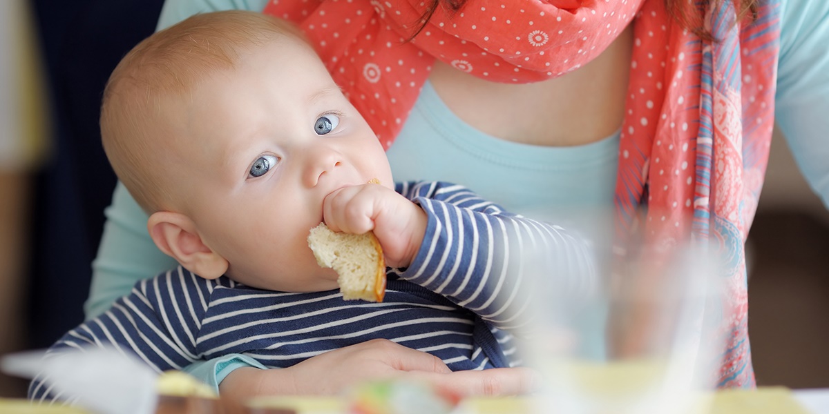 Infant eating first solid foods.