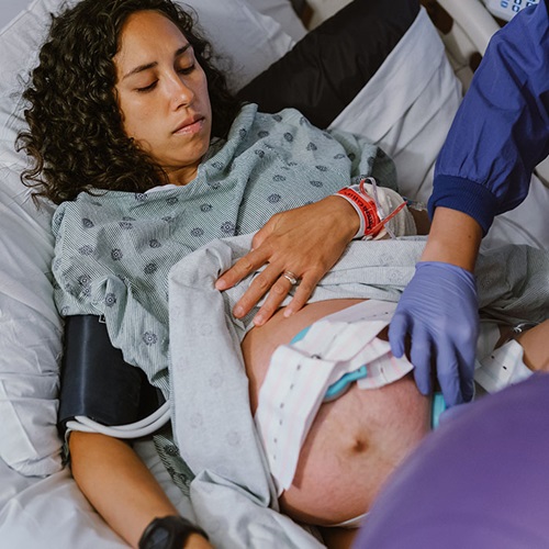 pregnant woman lying on a hospital bed with stomach exposed
