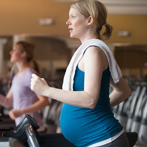 Pregnant woman running on a treadmill.
